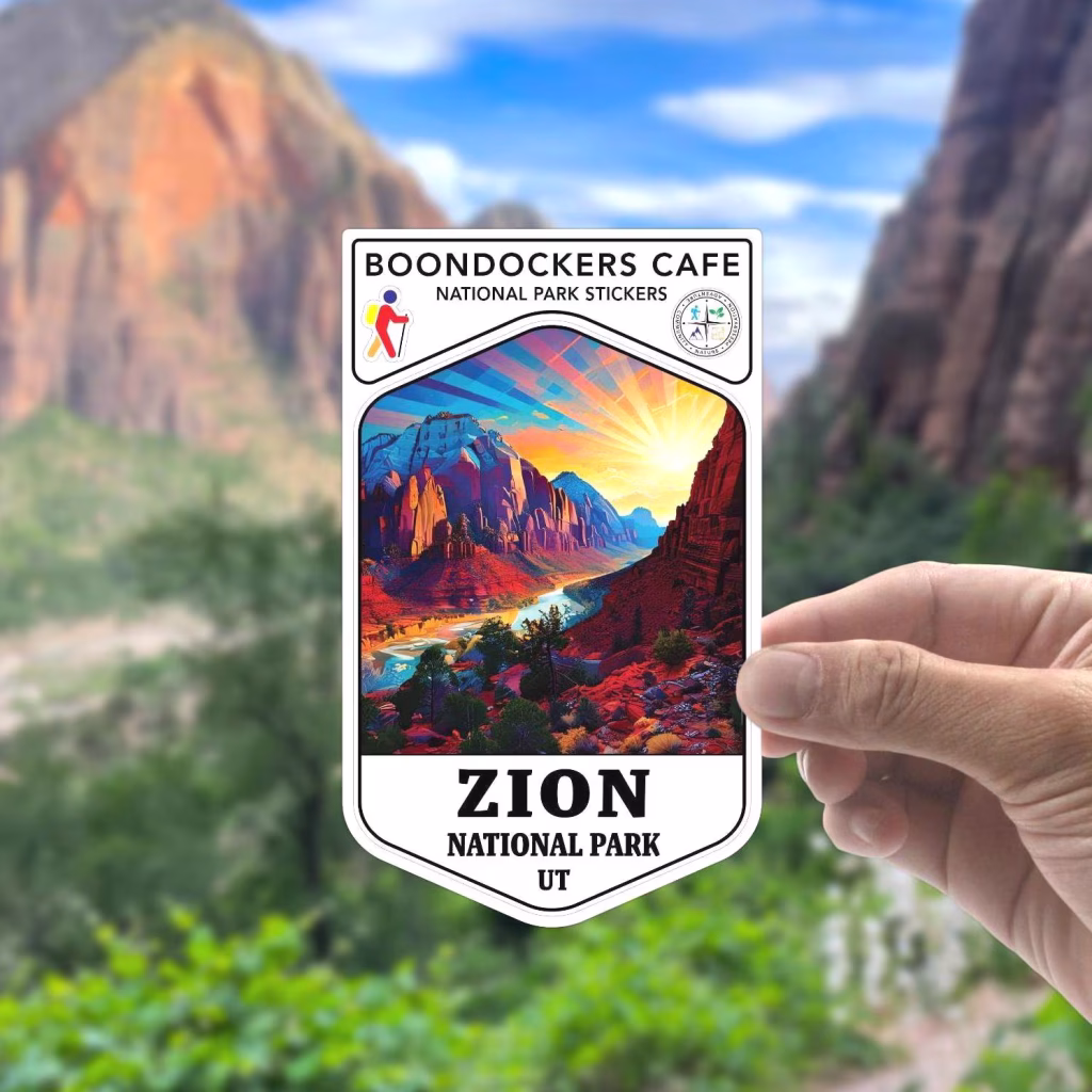 Zion National Park vinyl sticker with vibrant canyon artwork from Boondockers Cafe held in front of a real Zion vista. A colorful handcrafted decal for water bottles, journals, and travel gear. Celebrate your visit with this bold, durable keepsake. Available on Etsy.